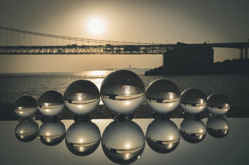 海岸の橋がリフレクションした水晶玉と光芒