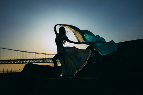 風にはためくダンサーの衣装のシルエット