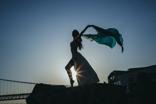 光芒の中でポーズを決めるダンサーのシルエット