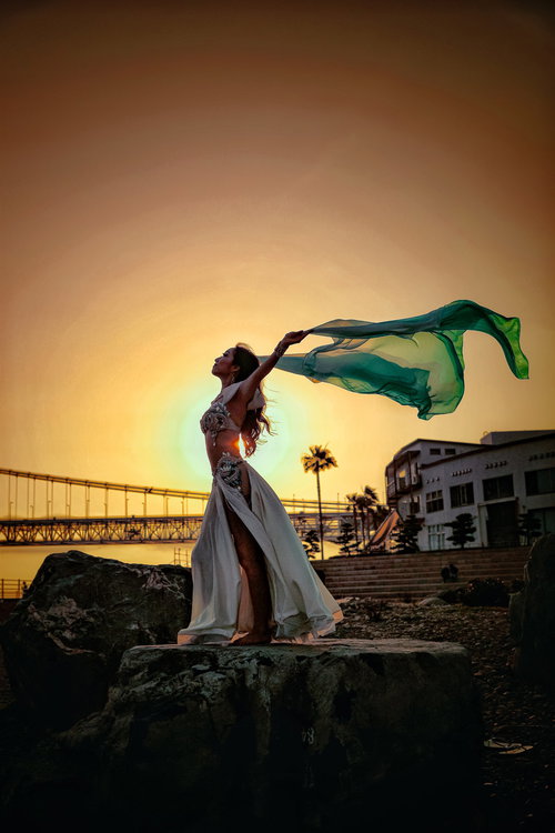 黄金色に染まる空で長い布をなびかせて踊る踊り子