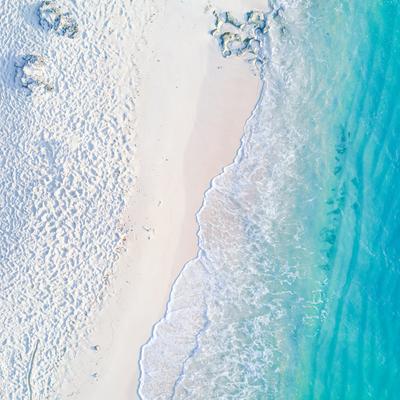 真上から撮影された白い砂浜と澄んだ海の写真