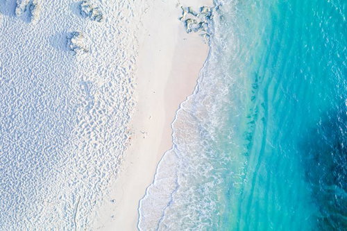 真上から撮影された白い砂浜と澄んだ海