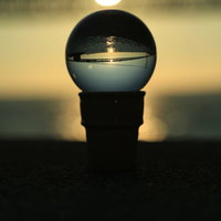 水晶に映る夕日と橋のシルエット、夕焼けの風景の写真