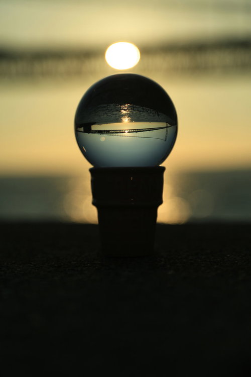 水晶に映る夕日と橋のシルエット、夕焼けの風景