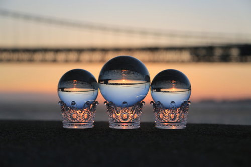 焼けた夕焼け空と台座に乗った水晶玉の逆像