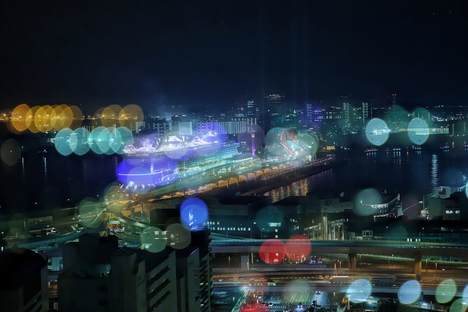 ネオンライトが玉ボケになる都市夜景 夜間の街灯とビルの写真素材 