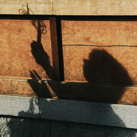 石壁に映る錫杖を持つ僧侶の人影シルエットの写真