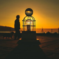 オブジェの上に置かれたガラス玉と夕焼けの風景の写真