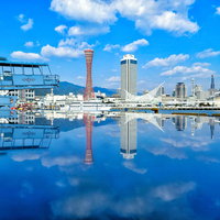水鏡に映る神戸のシーエリアの港町風景と青空の建物反射の写真