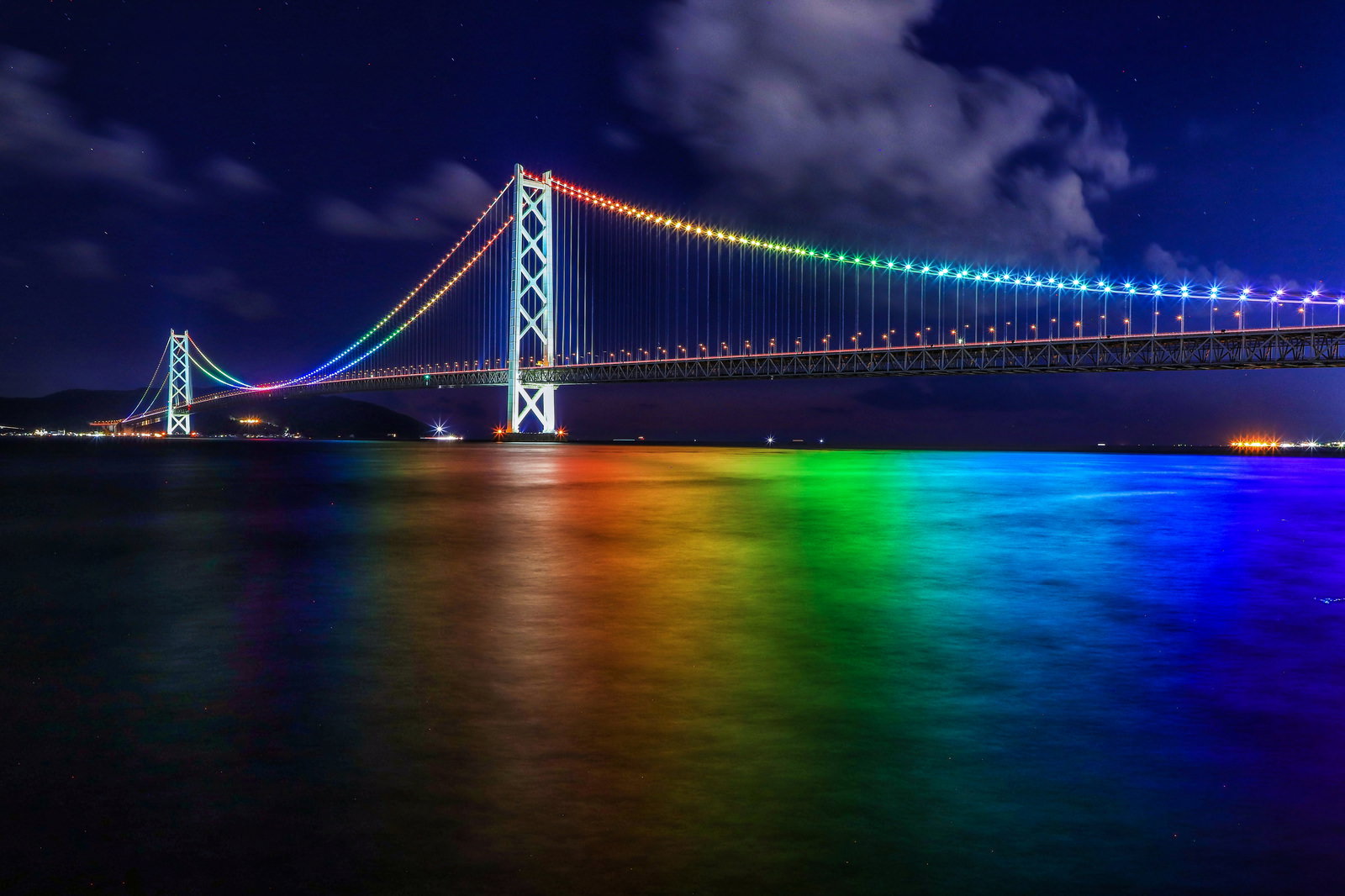 虹色にライトアップされた明石海峡大橋の夜景