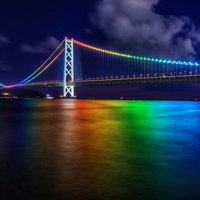 虹色にライトアップされた明石海峡大橋の夜景の写真