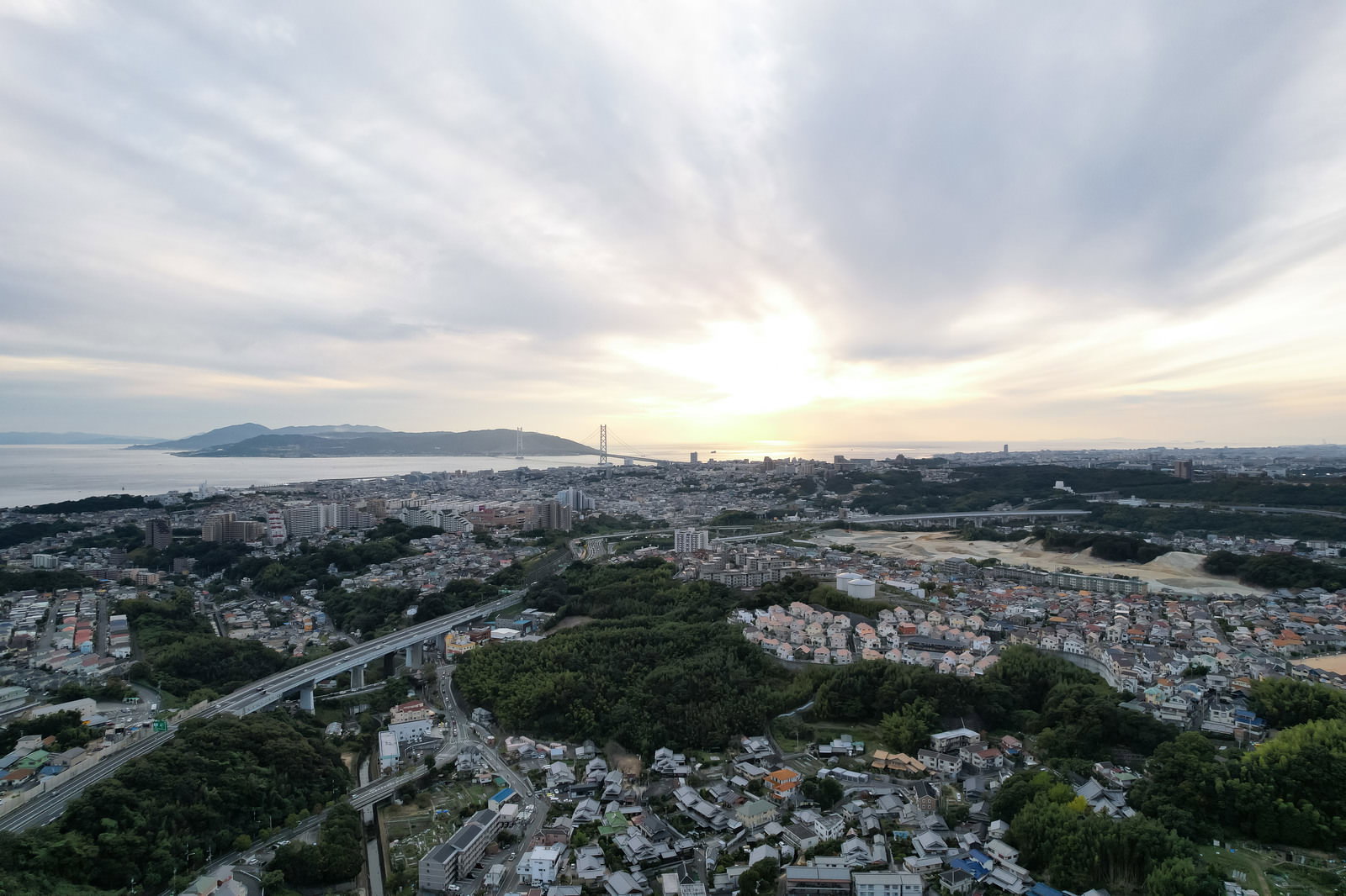 夕焼けに染まりかけた空の下に広がる住宅街の風景