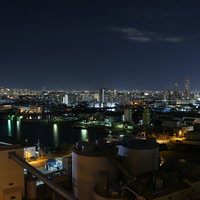 真っ暗な夜空と窓明かりが灯る住宅街の夜景の写真