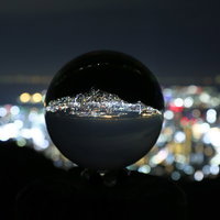 ガラス玉に映る反転した夜景と玉ボケ、街灯の光の写真