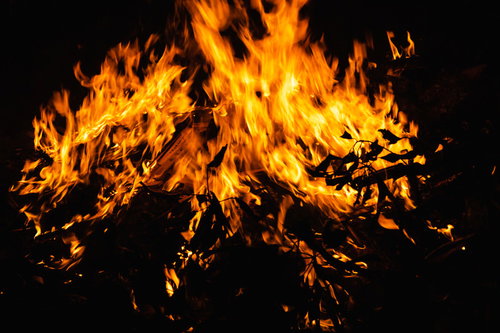 門戸厄神の火中に揺らぐ供物と炎の情景