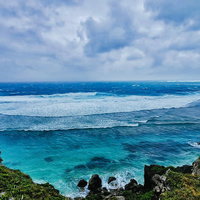 宮古島の海岸から望む白い波と青い海の写真