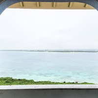 窓枠越しに見える宮古島の青い海と南国の景色の写真