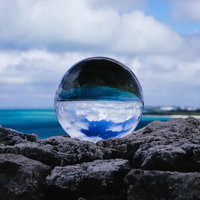南国の海岸に置かれた透明な水晶玉の風景の写真