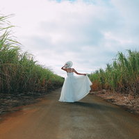 南国リゾートの道を歩くウェディングドレスの女性の後姿の写真