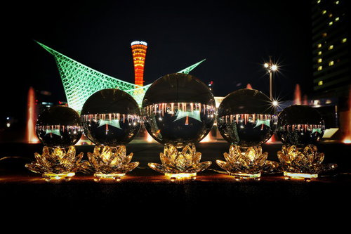 神戸の夜景を映す台座上に並ぶ水晶玉の夜間風景