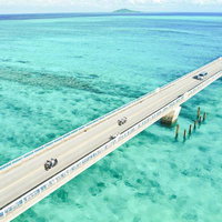 透明感あふれるエメラルドグリーンの海と白砂の波打ち際の写真