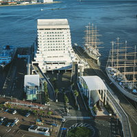 埠頭脇に停泊する白いフェリー船と港湾施設の写真