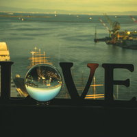 LOVEのガラス玉越しに望む夕焼けの埠頭の写真