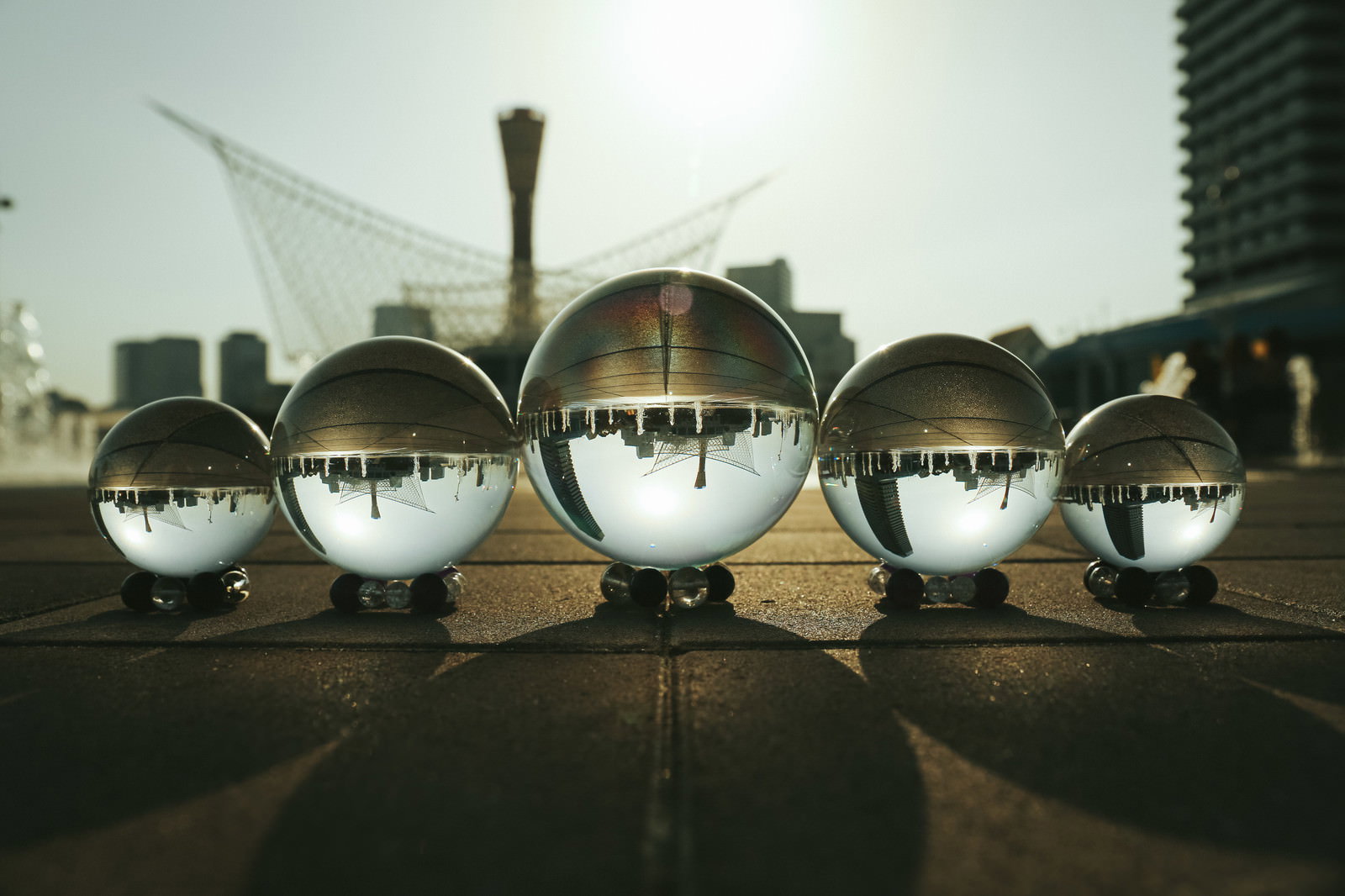 アスファルトの路面に置かれた水晶球が街並みを映し込み影を作る