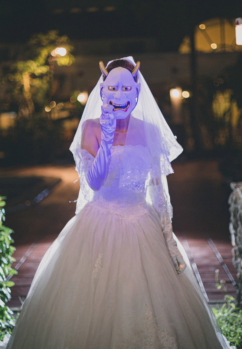 ウェディングドレスとベールを着用した女性が夜景を背景にポーズを取っている［モデル：モデルリリース］