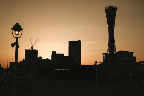 夕焼けに染まる街並みのシルエット、オレンジ色の空と建物