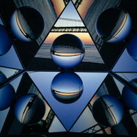 青い反射鏡に映るガラス玉と水晶の万華鏡デザインの写真