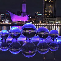 ライトアップされた夜景に映る水晶玉が一列に並ぶの写真