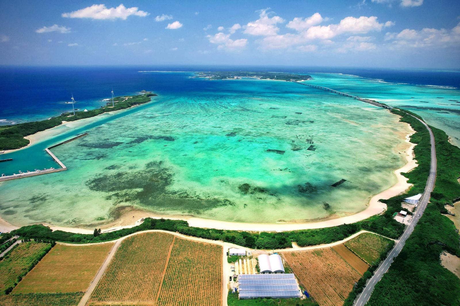 伊良部大橋と透明な海、白砂ビーチと農地が見える宮古島の空撮