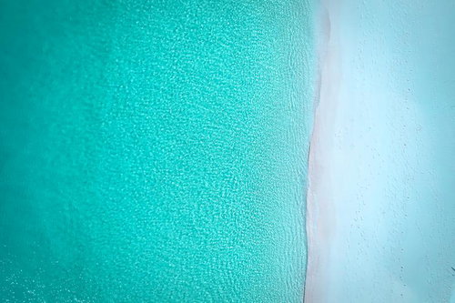 宮古島の白い砂浜と澄んだ海を真上から撮影