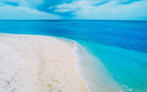 エメラルドグリーンの青い海と波打ち際、白い砂浜