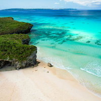 宮古島のエメラルドビーチと岩崖の俯瞰の写真