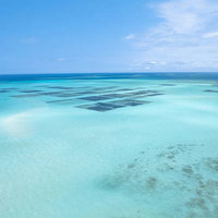 宮古島の南国の楽園を見渡す水平線と養殖筏の写真