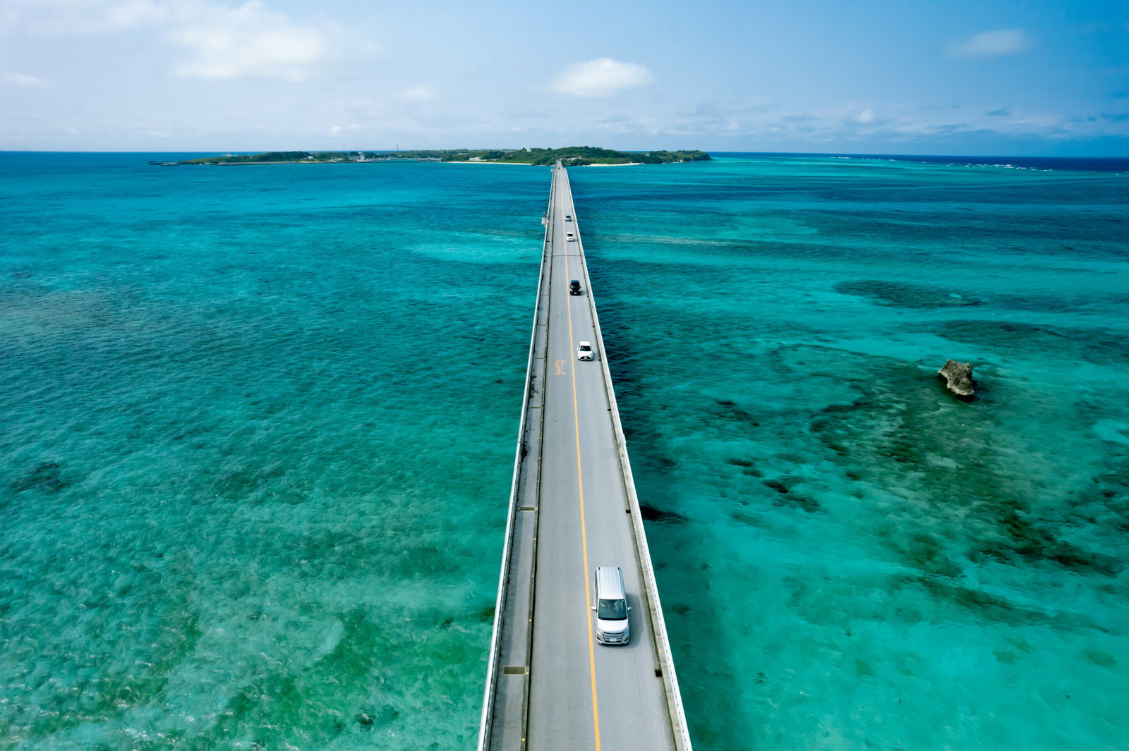 池間大橋を走る車と青緑の海の空撮