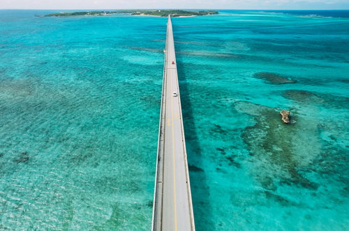 池間大橋を行き交う車と透き通るターコイズブルーの海