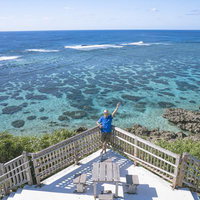 イムギャーマリンガーデンの絶景スポットで両手を上げて喜ぶ男性の写真