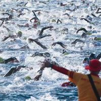 トライアスロン競技で大勢の選手たちが泳ぐ開始直後の写真