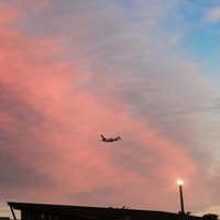 夕焼け雲を背景に飛び立つ旅客機のシルエットの写真