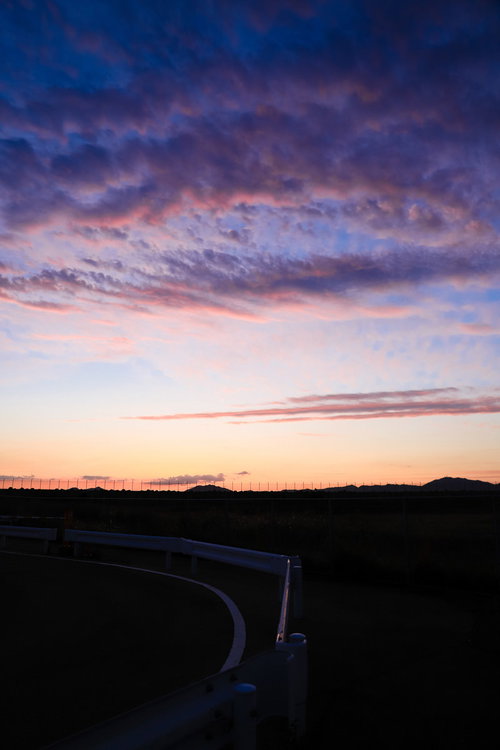 トワイライトの時と焼けた空の田舎道：夕暮れ時の風景