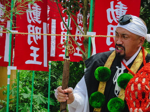 お焚き上げの供養を行う白装束の住職