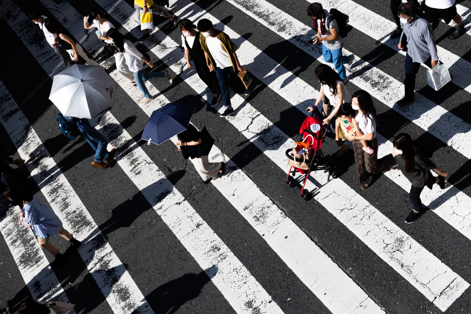 白い縞模様の横断歩道を複数の人が渡っている俯瞰の様子