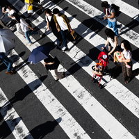 横断歩道を渡る人々の人混み、俯瞰で映す都市の歩行者たちの流れの写真