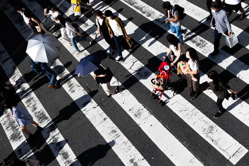 横断歩道を渡る人々の人混み、俯瞰で映す都市の歩行者たちの流れ