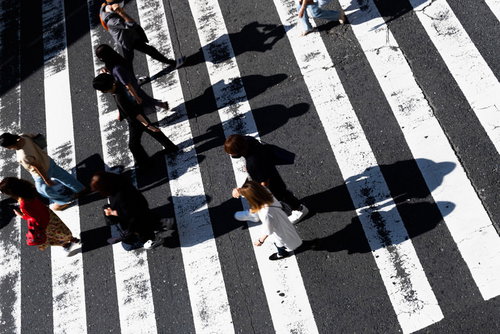 白い縞模様の横断歩道を行き交う人影
