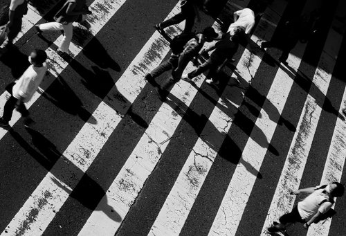 横断歩道を渡る人々のモノクロシルエット