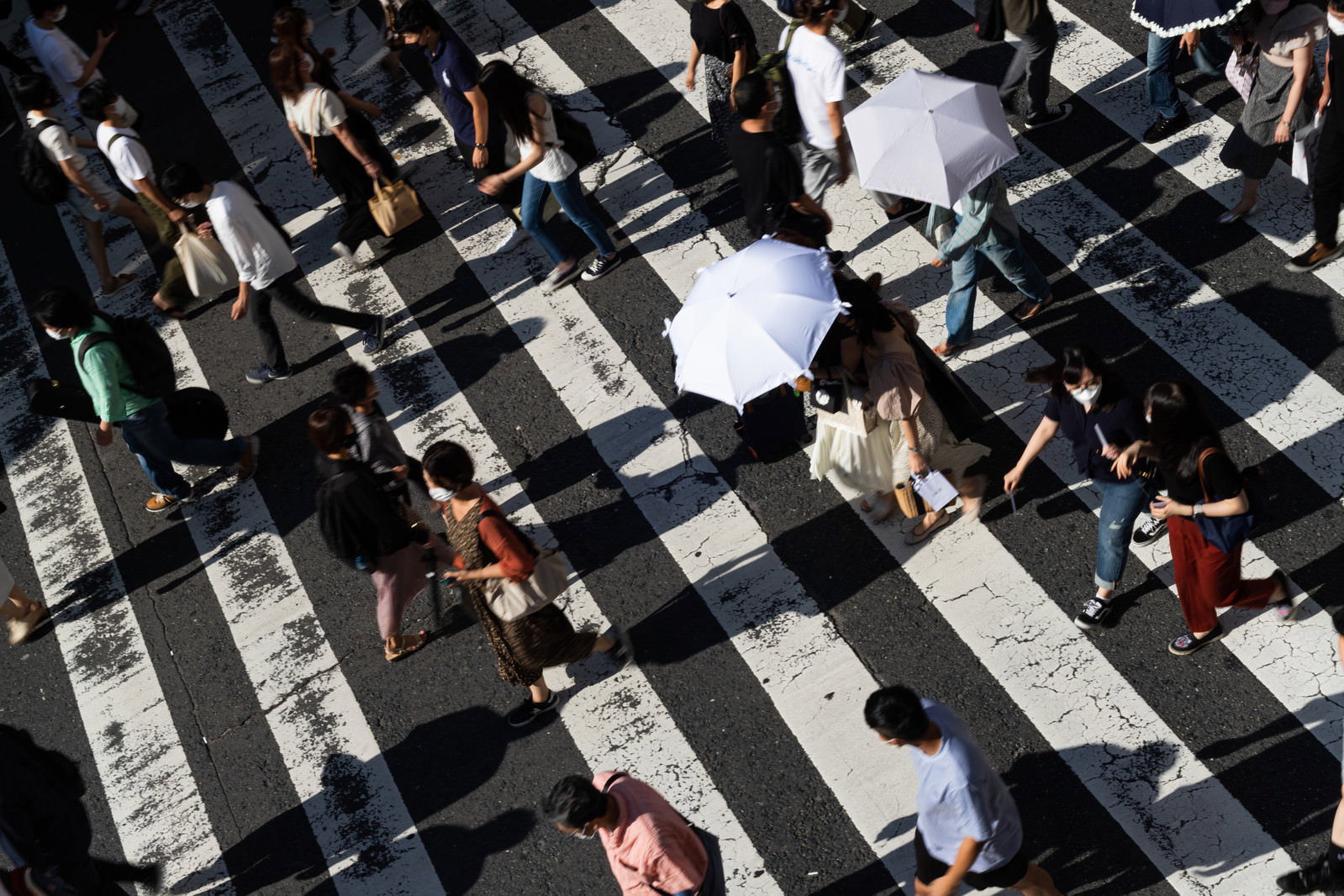 横断歩道を歩く多くの人々を上から撮影した写真